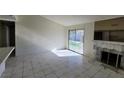 Bright living room with tile flooring, fireplace, and sliding door to the backyard at 1673 Caliente Ct, Las Vegas, NV 89119