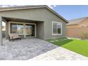 Relaxing backyard boasts a covered patio, minimal synthetic lawn and decorative pavers, perfect for outdoor enjoyment at 2114 Cold Canyon Ave, North Las Vegas, NV 89086