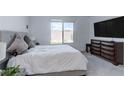 Comfortable bedroom features a plush bed, carpeted floors, and a large window for natural light and scenic views at 2114 Cold Canyon Ave, North Las Vegas, NV 89086