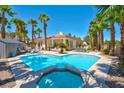 Beautiful backyard pool and jacuzzi surrounded by tropical landscaping and patio furniture at 2290 Casa Bella Ct, Las Vegas, NV 89117