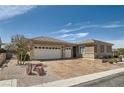 Attractive single-story home with a three-car garage, desert landscaping, and a tile roof under a blue sky at 2743 Evergreen Oaks Dr, Henderson, NV 89052