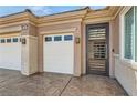 Close up of home's garages, gated entrance, and desert landscaping at 2743 Evergreen Oaks Dr, Henderson, NV 89052