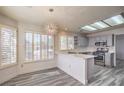 Eat-in kitchen features wood-look floors, white counters, gray cabinets, and stainless steel appliances at 2824 Dry Plains Dr, Las Vegas, NV 89134