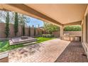 Covered patio featuring a brick fire pit, artificial turf, and built-in outdoor grill perfect for entertaining at 3 Glendora Ct, Henderson, NV 89052