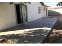 A plain concrete back patio with access to the main house and a walled-in block fence at 3258 Glenhurst Dr, Las Vegas, NV 89121