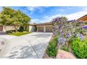 Lovely home exterior showcasing lush landscaping, a wide driveway, and colorful blooming bushes at 4 Annadale Ct, Henderson, NV 89052