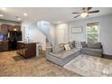 Open-concept living room featuring tile flooring and a plush grey sectional couch, bathed in natural light from a nearby window at 4610 Lime Straight Dr, Las Vegas, NV 89115