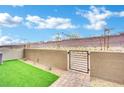 Enclosed backyard with artificial turf, paver patio, and block wall fencing at 600 N Carriage Hill Dr # 1008, Las Vegas, NV 89138