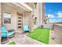 Inviting patio area with outdoor seating, artificial turf, and modern facade at 600 N Carriage Hill Dr # 1008, Las Vegas, NV 89138