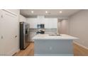 Well-lit kitchen with modern white cabinets, stainless steel appliances, and quartz countertop island at 6145 May River St, Las Vegas, NV 89148