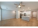 Open concept living room and kitchen with hardwood floors and ceiling fan at 6145 May River St, Las Vegas, NV 89148