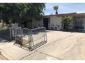 Charming single-story home featuring mature trees and a secure gated entry at 725 Miller Ave, North Las Vegas, NV 89030