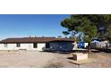 A large lot with a home that has a brown roof and a blue container in the far background at 7990 Firethorn, Las Vegas, NV 89123