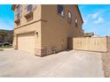 Attached two-car garage with additional parking space behind secure metal gate at 824 Bussora Rose Dr, Henderson, NV 89015