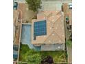 Aerial view of a home featuring solar panels on the tile roof and a lush green lawn at 8980 Tumbling Pebble Way, Las Vegas, NV 89123