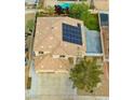 Bird's-eye view of a property with solar panels, a tile roof, and a well-kept backyard at 8980 Tumbling Pebble Way, Las Vegas, NV 89123