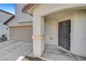 Covered home entrance featuring a gray metal door and decorative beige concrete columns at 9073 Spoonbill Ridge Pl, Las Vegas, NV 89143