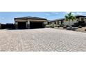 Single story home featuring a large brick driveway, a two-car garage and desert landscaping at 9511 Star Vista Ct, Las Vegas, NV 89149