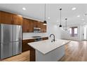 Bright kitchen features an island with white countertops, stainless steel appliances and wood plank flooring at 11756 Emerald Lake Ave, Las Vegas, NV 89138