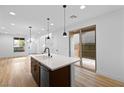 Bright, modern kitchen with white countertops, dark cabinets, stainless steel appliances and wood floors at 11756 Emerald Lake Ave, Las Vegas, NV 89138