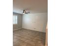 Bright living room featuring tile flooring, plantation shutters, and a modern ceiling fan at 1197 Mission View Ct, Henderson, NV 89002