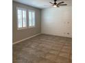 Bright living room featuring tile flooring, plantation shutters, and a modern ceiling fan at 1197 Mission View Ct, Henderson, NV 89002