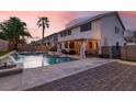 Expansive backyard oasis featuring a pool with water features, a covered patio, and ample space for outdoor dining at 1283 Peppercorn Ave, Henderson, NV 89012