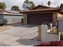 View of the home's exterior showing a spacious driveway and two-car garage at 1732 Yellow Rose St, Las Vegas, NV 89108