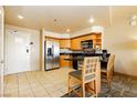 A spacious kitchen with stainless steel appliances, wooden cabinets, and a breakfast bar at 211 E Flamingo Rd # 714, Las Vegas, NV 89169