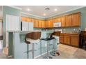 Kitchen featuring wooden cabinets, light countertops, and bar stool seating at 2388 Aztec Ruin Way, Henderson, NV 89044