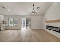 Bright and airy living room featuring wood floors, modern fireplace, shiplap accent wall, and stylish chandelier at 3009 Anna Bay Dr, Las Vegas, NV 89134