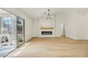 Spacious living room with vaulted ceilings, modern fireplace, shiplap, wood floors, and sliding glass doors at 3009 Anna Bay Dr, Las Vegas, NV 89134