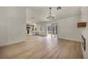 Open-concept living room with wood floors, fireplace, stylish chandelier, and seamless flow to kitchen and patio at 3009 Anna Bay Dr, Las Vegas, NV 89134