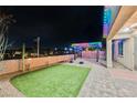 Inviting backyard with a pergola covered in multi-colored festive lighting at 3096 Beaux Art Ave, Henderson, NV 89044