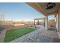 Inviting backyard featuring a covered patio, synthetic lawn, and rock landscaping at 3096 Beaux Art Ave, Henderson, NV 89044