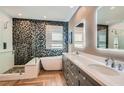 Modern bathroom featuring a soaking tub, double vanity, decorative tile, and walk-in shower at 537 Tuscany View St, Las Vegas, NV 89145