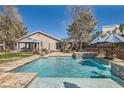 Backyard pool with travertine tile deck, mature trees, a built in hot tub and privacy landscaping at 537 Tuscany View St, Las Vegas, NV 89145