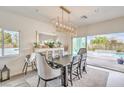 Dining room with a contemporary chandelier, sliding glass doors, and views of the beautiful outdoor pool at 5755 E La Campana Dr, Pahrump, NV 89061