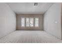Bright bedroom featuring neutral paint, a large window, and carpeted floor at 6032 Port Of Dreams Dr, Las Vegas, NV 89130