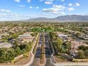 Stunning aerial view of a well-maintained neighborhood with tree-lined streets and mountain views in the distance at 6895 Kelp Ledge Ct, Las Vegas, NV 89131