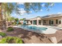 Backyard oasis with a sparkling pool, lush landscaping, and patio with unobstructed views at 6895 Kelp Ledge Ct, Las Vegas, NV 89131