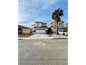 Two-story stucco house with a two car garage, stone accents, and a palm tree in the front yard at 7977 Blue Brook Dr, Las Vegas, NV 89147