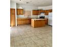 Kitchen with tile flooring, oak cabinets, and a center island at 7977 Blue Brook Dr, Las Vegas, NV 89147