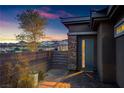 Stylish home entrance featuring a modern front door, stone accents, and tranquil courtyard ambiance at 8 Reflection Cove Dr, Henderson, NV 89011