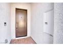 Contemporary front entry featuring a bronze door, exterior lighting, and modern stucco at 9057 N Skye Treeline St, Las Vegas, NV 89166
