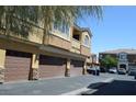 Exterior shot of the residential building with several garages and cars at 9303 Gilcrease Ave # 1097, Las Vegas, NV 89149