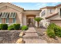 Inviting covered entry and tiled walkway with stone accents lead to this lovely home at 1303 Panini Dr, Henderson, NV 89052