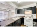 Functional kitchen with dark cabinetry, gas range, breakfast bar, and view to the outdoor space at 1501 Living Desert Dr # A, Las Vegas, NV 89119