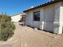 Side exterior of a single-story home with gravel landscaping and a red tile roof at 1617 Joshua Tree Ct, Las Vegas, NV 89108
