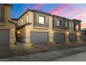 Townhome showcases garages, stone accents, and neutral color schemes under a vibrant sky at 207 Callen Falls Ave # 1713, Henderson, NV 89011